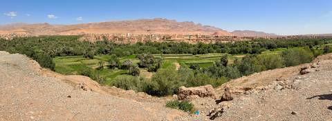       Expansive landscape with ancient village and lush greenery.
  