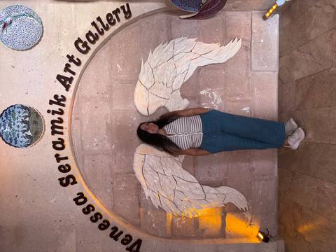       Person standing with angel wing wall art.
  