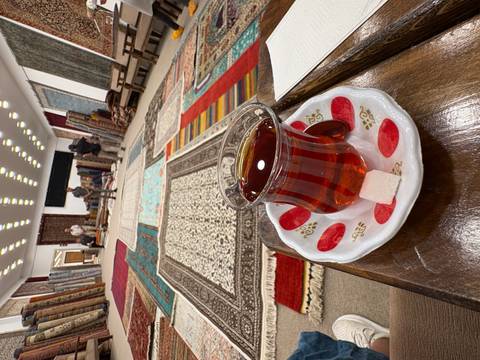       Traditional Turkish tea served on a table in a carpet shop.
  