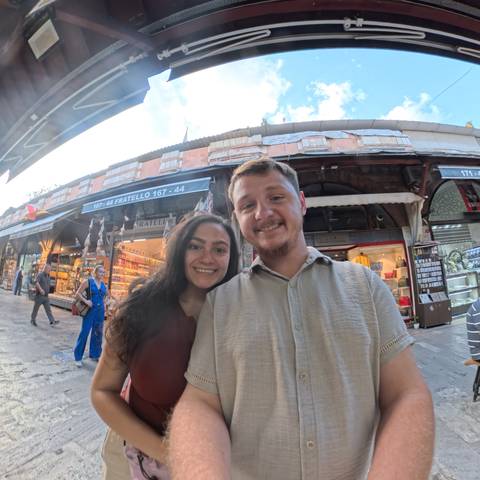       Smiling couple in a busy marketplace.
  