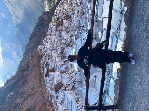 Person standing in front of white terraces at Salineras de Maras.
