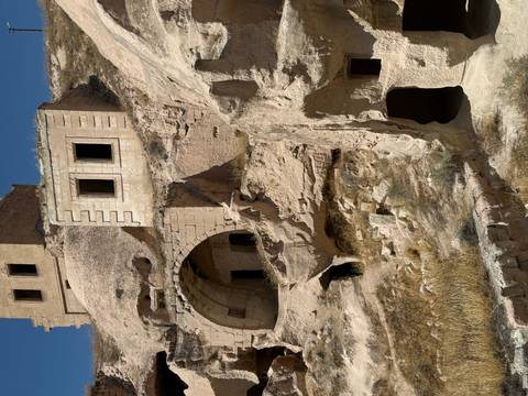 Close-up of ancient stone structures built into rock at an archaeological site.