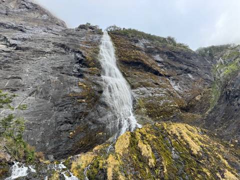 Tall waterfall descending down a sheer rock face.