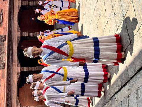       Group of people in traditional attire performing a dance.
  