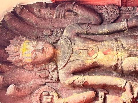       A colorful, intricate stone statue with gold detailing.
  