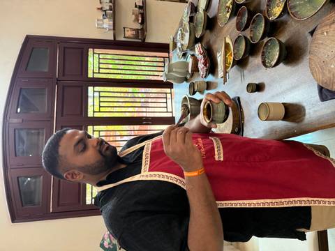 A man preparing a beverage in a kitchen setting, possibly a local cooking class.