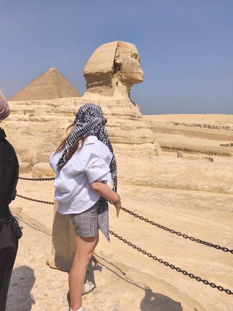 Woman in headscarf looking towards the Sphinx.