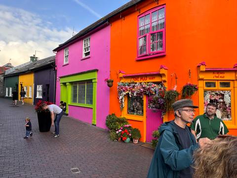 People in front of vibrant, colorful buildings.