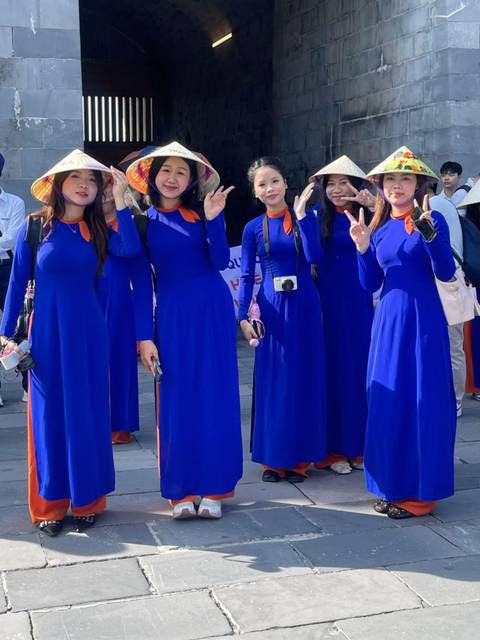 Group of women wearing blue dresses posing and smiling.
