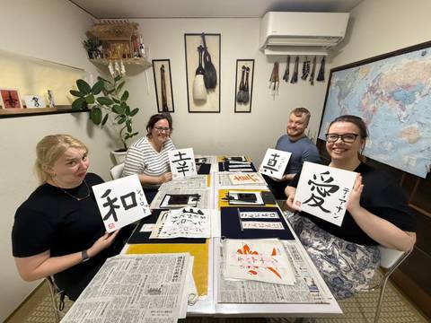 Group of people in a room displaying calligraphy in Japan.