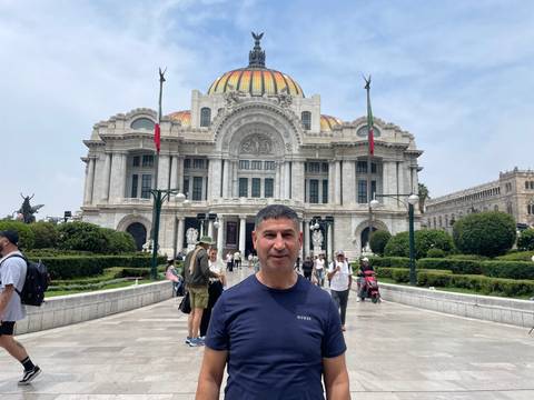      A person in front of an ornate building.
  