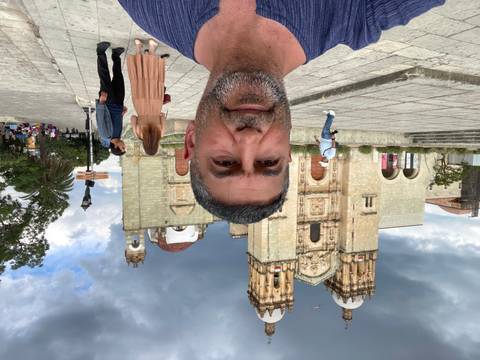       A person in front of an old church.
  