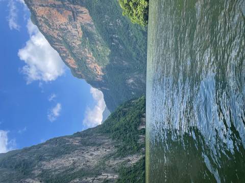 River between steep cliffs under a clear sky.