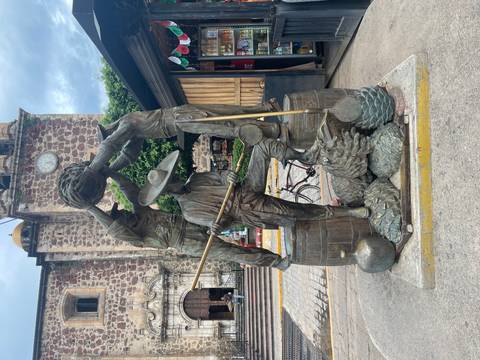 Bronze statue of men involved in traditional activities.