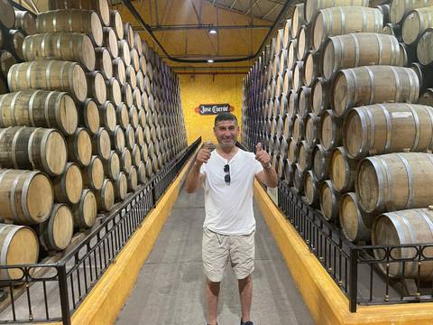 Person in a cellar surrounded by numerous barrels.