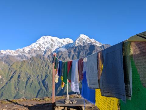 Prayer flags with snow-capped mountains in the background.
