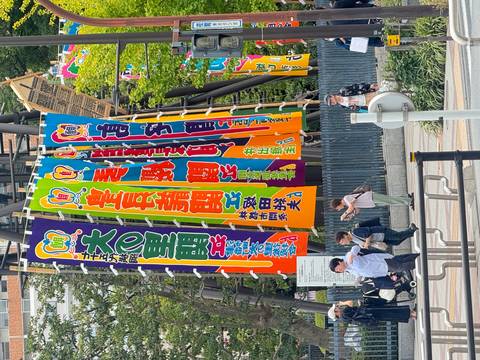       Colorful banners with people walking past.
  