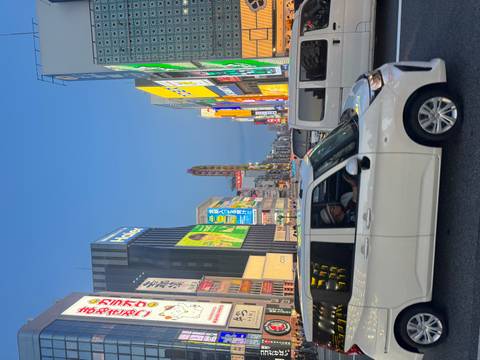       Bustling city street at dusk with lit signs.
  