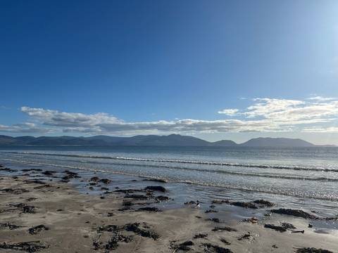       Beautiful coastal view with mountains and clear sky.
  