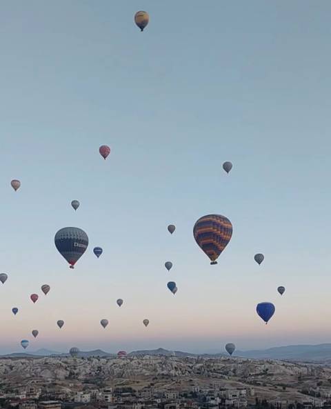 Numerous hot air balloons floating in the sky.