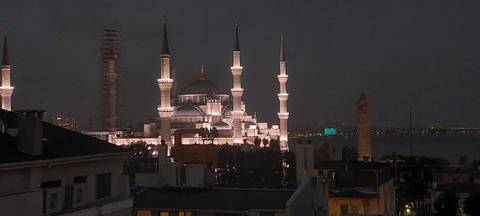 A majestic mosque lit up against a night sky.