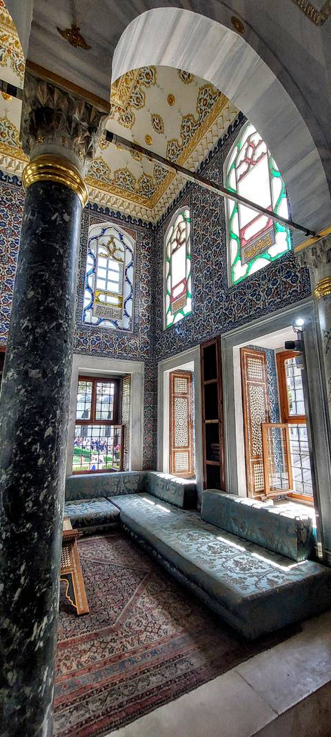 Interior of a building with ornate tiles and windows.
