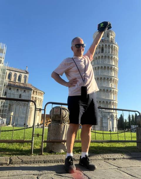 Person posing with the Leaning Tower of Pisa.