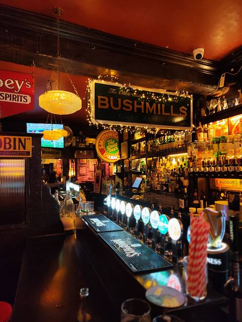 Interior of an Irish pub with various signs and lights.