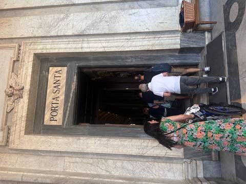 People entering a historical building with 'Porta Santa' inscription.