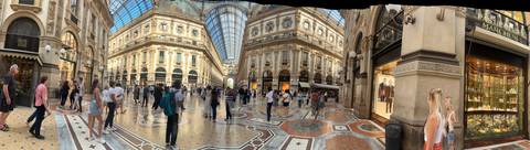 A bustling shopping gallery with an elegant glass roof.