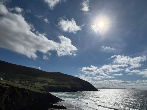 Coastal landscape with a view of the sea and sun in the sky.