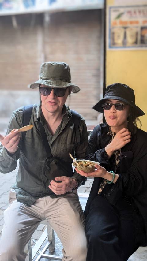       Couple enjoying a meal, with one holding a fork with food.
  