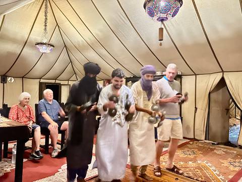       People in a tent enjoying traditional music performance.
  
