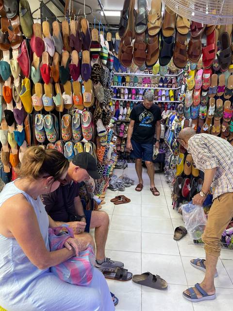       People shopping in a colorful shoe market.
  