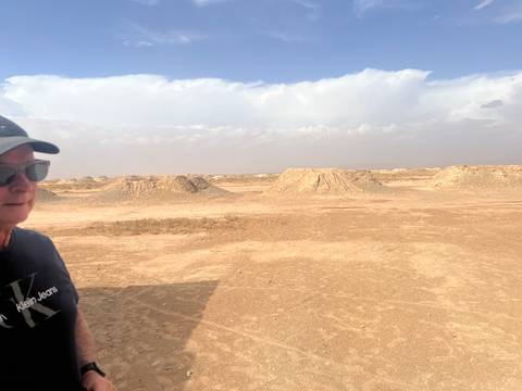 Person wearing sunglasses in a desert landscape.