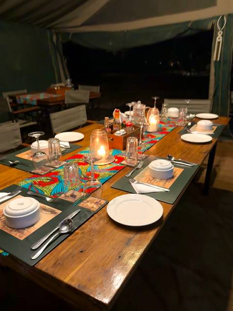       Table set for dinner with colorful table runner and candlelight.
  
