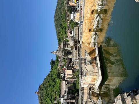 Historic building with a water feature and surrounding landscape.