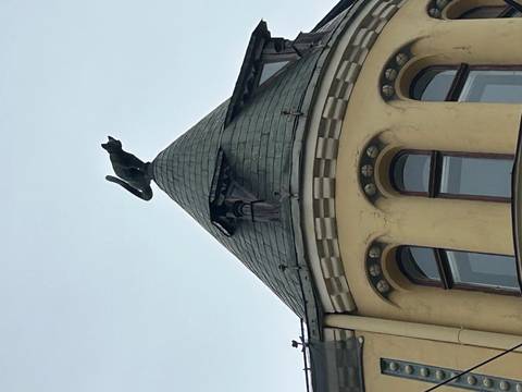Roof of a building topped with a cat sculpture.
