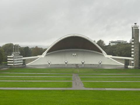 Wide amphitheater with an arching roof in an open space.