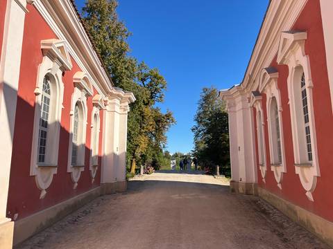 Beautiful architectural passage with pink and white buildings.