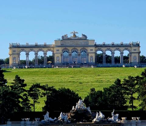      A historic building with archways on a grassy field.
  