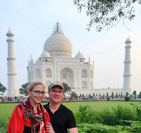 Two people standing in front of the Taj Mahal.