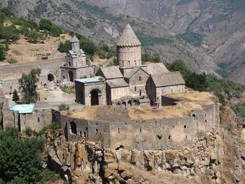       Ancient monastery on a cliff surrounded by mountains
  