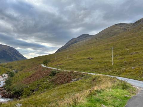       Winding road through a mountainous landscape with overcast sky.
  