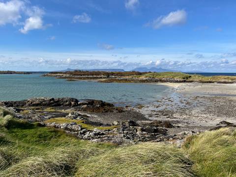       Coastal landscape with blue waters and rocky shores.
  