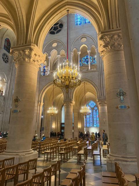 Interior of a large cathedral with chandeliers and stained glass.