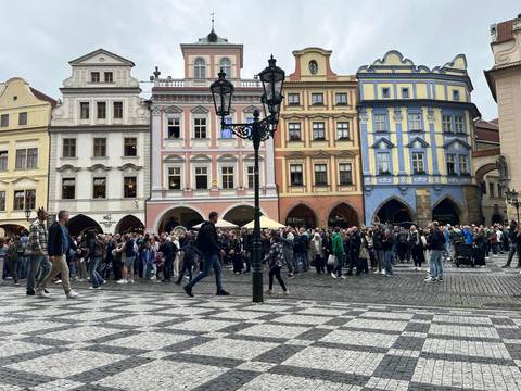       Colorful historic buildings in a busy town square with people walking.
  
