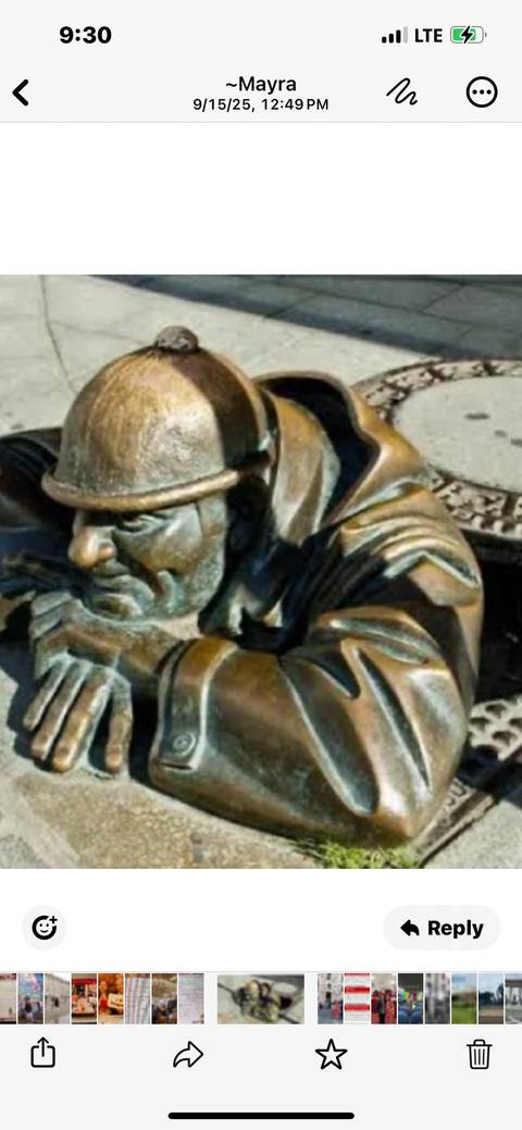Statue of a bronze worker emerging from a manhole.