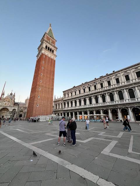       Saint Mark's Campanile and surrounding buildings in Venice's busy square.
  
