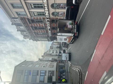       City street with diverse architecture and vehicles on the road.
  